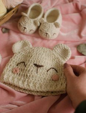 Cream crochet bear-ear baby hat with matching bunny-ear booties made from the tutorial